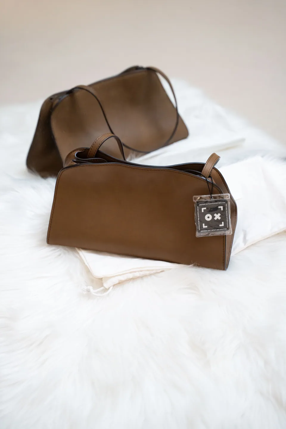 Brown leather accessories photographed on a light surface