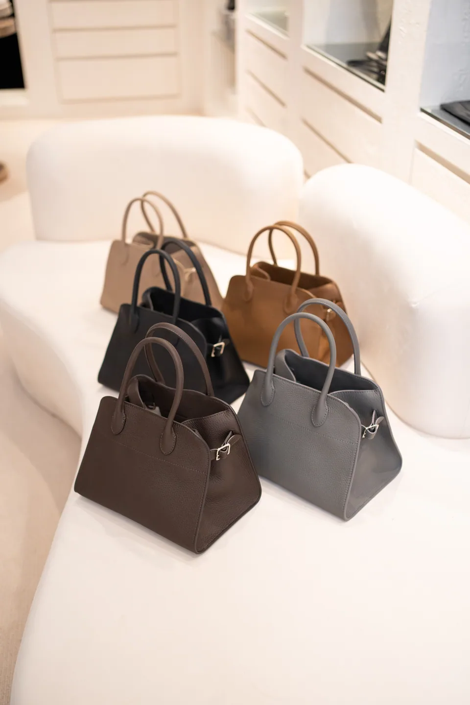 Neutral-toned leather handbags displayed in the Society in Fame showroom
