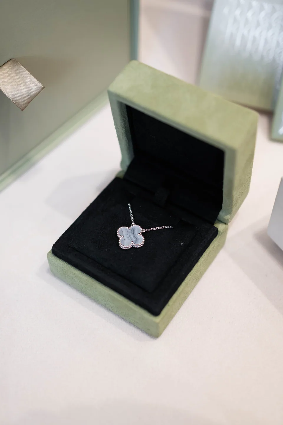A delicate clover pendant presented in a jewellery box