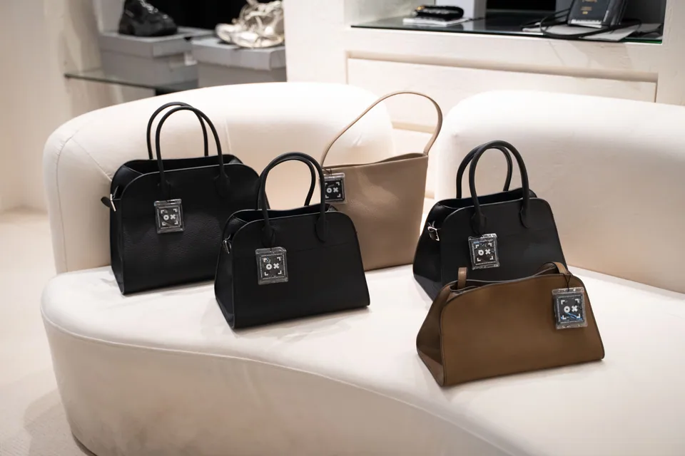 Leather handbags arranged on a curved sofa inside the Society in Fame showroom
